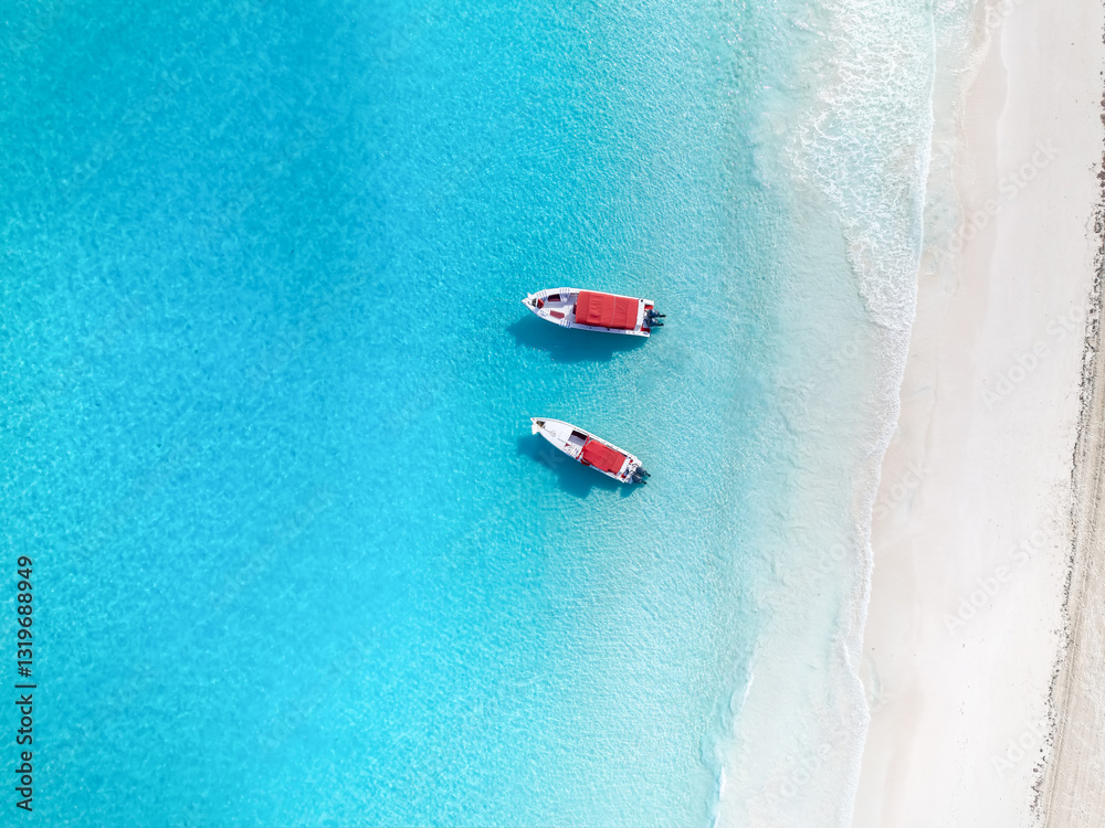 Aerial top down view of a tropical paradise beach at the Exuma islands, Bahamas, Caribbean Sea, with two moored excursion boats