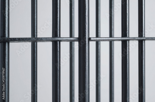 Close-up of realistic prison bars on a white background, highlighting the austerity and oppressive atmosphere of confinement.