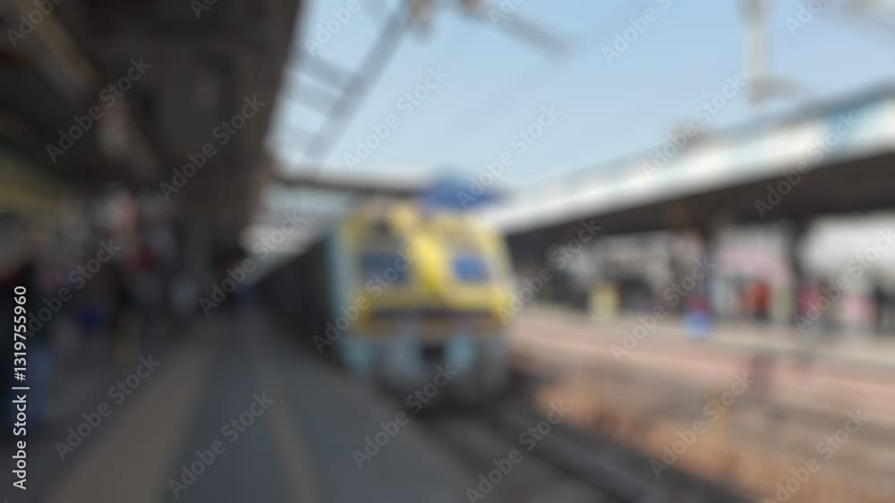 Local train with passangers arrives at the Andheri Railway Station platform. Blurred real time motion video for background.