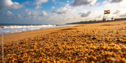 Coastal view at sunset depicting grains of sand with waves and a distant flag along the shore