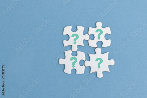 The image features four white puzzle pieces connected together on a blue background. Each piece has an blue question mark, symbolizing mystery, problem-solving, or searching for answers.