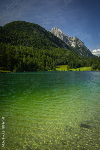 Crystal-clear Lake Lautersee in Bavaria, Germany with majestic Wetterstein Mountain of the German-Austrian Alps in Background on a sunny Summer Day with blue Sky; Copyspace photo