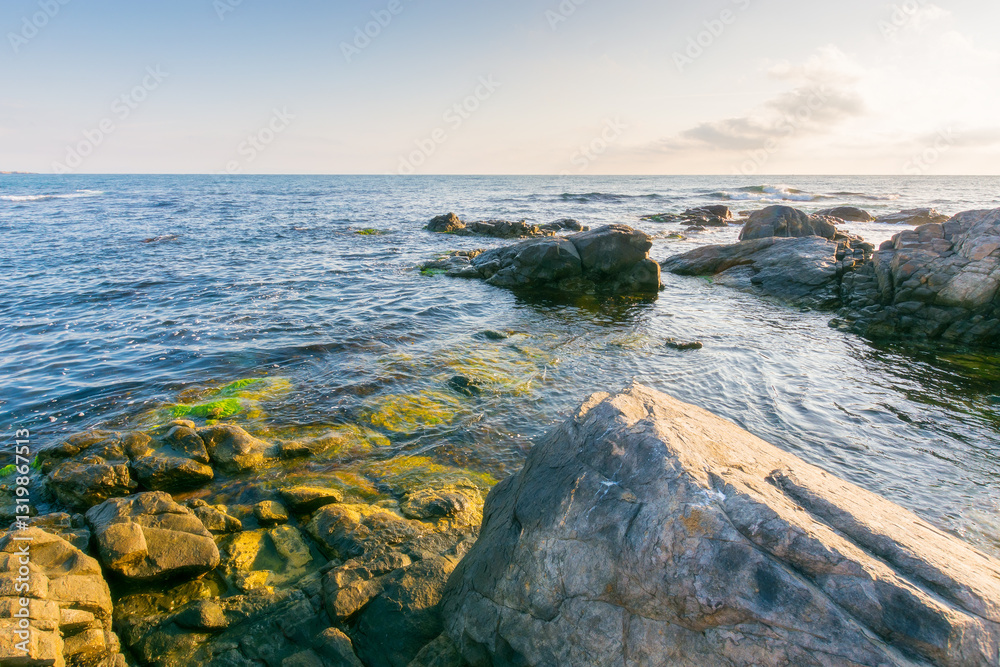 beautiful sunrise at the black sea. scenic seascape. rocky coast and clouds on the blue sky in morning light. summer vacations and weather change concept. travel background