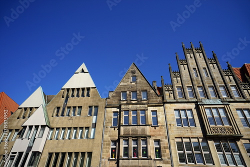 Schönes altes Kaufmannshaus und Altbau in Beige und Naturfarben vor blauem Himmel im Sonnenschein am Roggenmarkt in der City und Altstadt von Münster in Westfalen im Münsterland photo