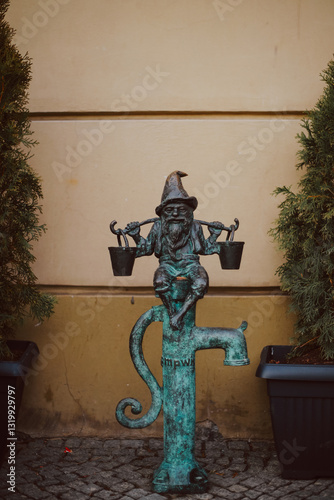 Fototapeta Naklejka Na Ścianę i Meble -  High-Quality Photograph of a Metal Bronze Gnome Statue in Wroclaw, Capturing Realistic Details, Urban Atmosphere, and the Charm of This Famous Polish City

