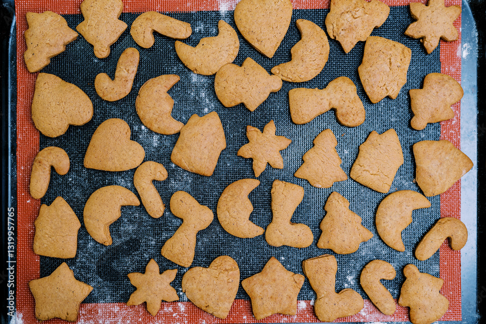 Fototapeta premium Freshly baked Christmas cookies lie on a baking sheet. Top view