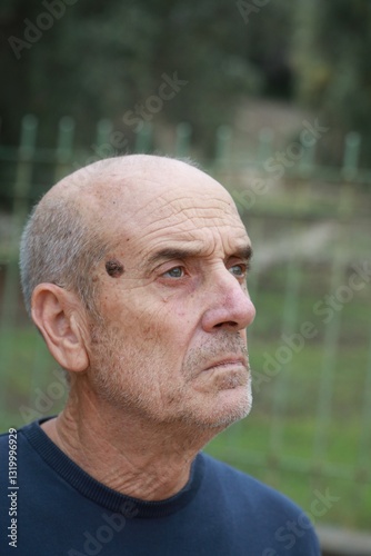 Elderly Man Looks Around Suspiciously In The Park