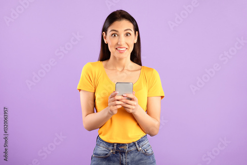 Surprised positive lady using smartphone device, chatting online, typing sms, glad to recieve many messages of congratulation on mailbox, looking overjoyed at camera, connected to wireless internet