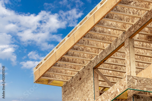 Roof construction detail showing engineered wood joists and Laminated Veneer Lumber (LVL) headers  with oriented strand board, Chip board wall sheathing

