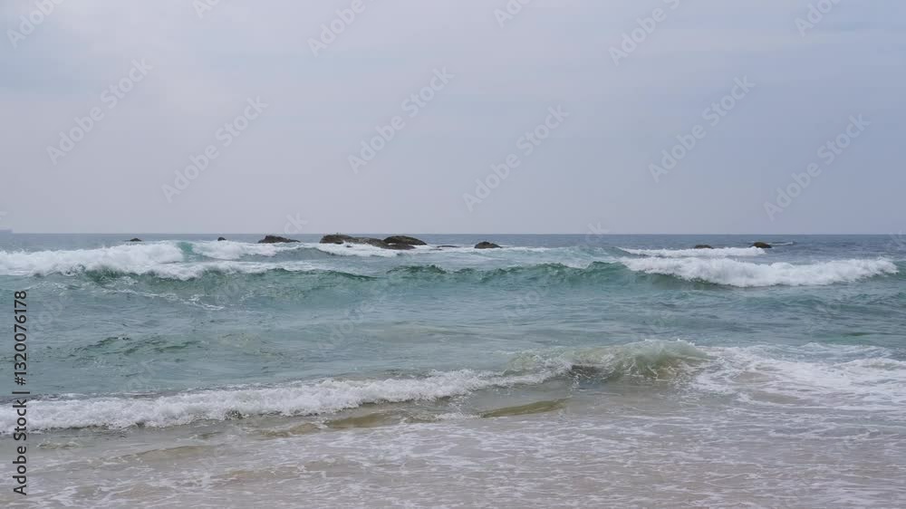 Waves crash against the rocks on the beach, sea spray in the air, sunlight reflects on the water. The natural movement of ocean waves hitting an uneven stone shore. travel, and atmosphere. 4K video. Waves crash against the rocks on the beach, sea spray in the air, sunlight reflects on the water. The natural movement of ocean waves hitting an uneven stone shore. travel, and atmosphere. 4K video.