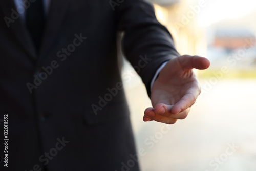 Man offering helping hand on city street, closeup