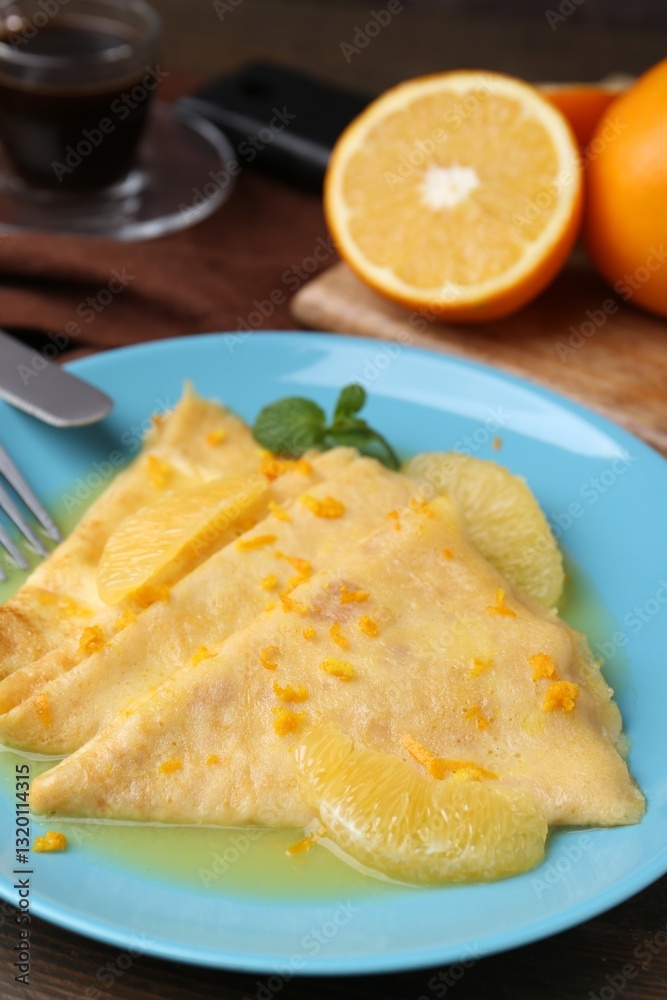 Plate with tasty crepes Suzette on wooden table, closeup Plate with tasty crepes Suzette on wooden table, closeup