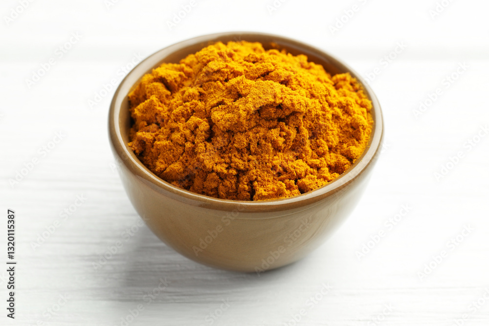 Turmeric powder in bowl on white wooden table, closeup Turmeric powder in bowl on white wooden table, closeup
