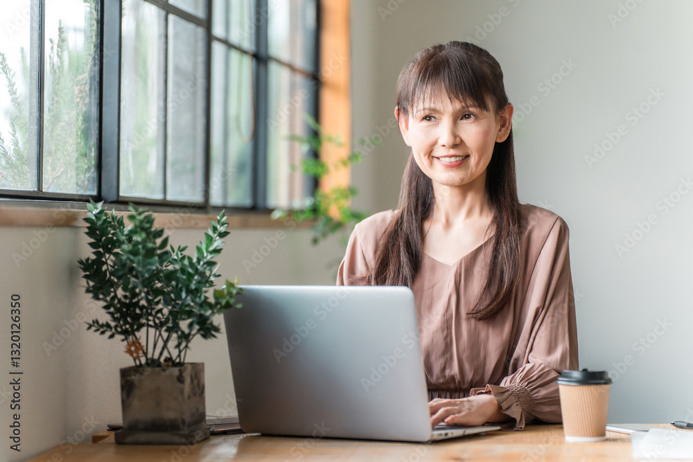 カフェでテレワーク・ノマドワークする中高年のアジア人女性
カフェでテレワーク・ノマドワークする中高年のアジア人女性