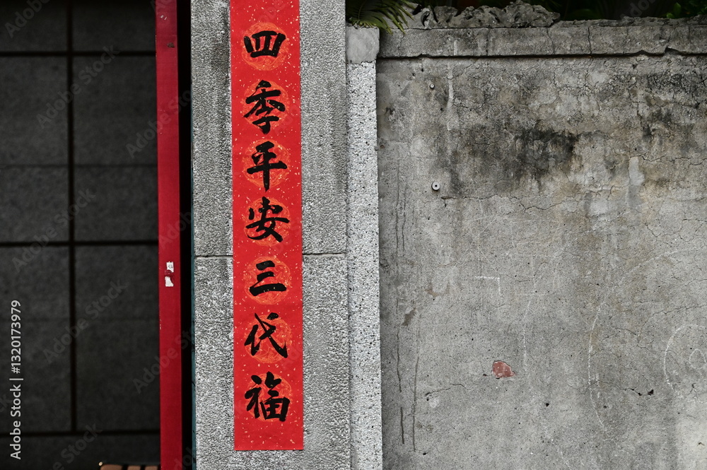 TWN - Feb 16, 2025: Red spring couplets, inscribed with meaningful Chinese blessings, decorate the entrance of an old home. The words convey hopes for family harmony and prosperity throughout the year
