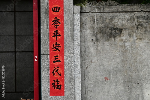Obraz na płótnie TWN - Feb 16, 2025: Red spring couplets, inscribed with meaningful Chinese blessings, decorate the entrance of an old home. The words convey hopes for family harmony and prosperity throughout the year w salonie