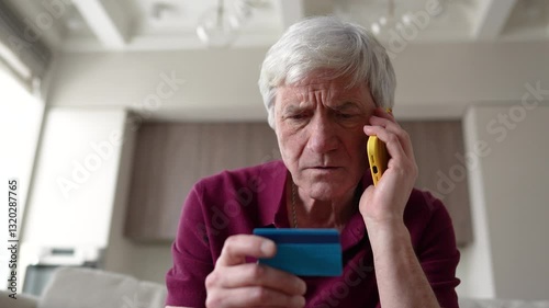 Trusting serious feared pensioner giving away card number to fraudsters over phone. Financial scam, identity theft, bank card fraud, information theft manipulation, deception, vulnerable individual