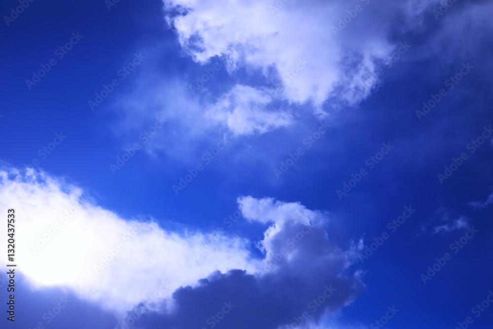 Obraz premium 太陽光で透き通るような雲と紺碧の空