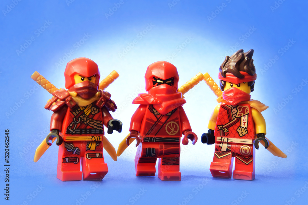 Naklejka premium Editorial illustrative image of lego ninjago minifugure of Kai red ninja with golden sword weapon on blue background