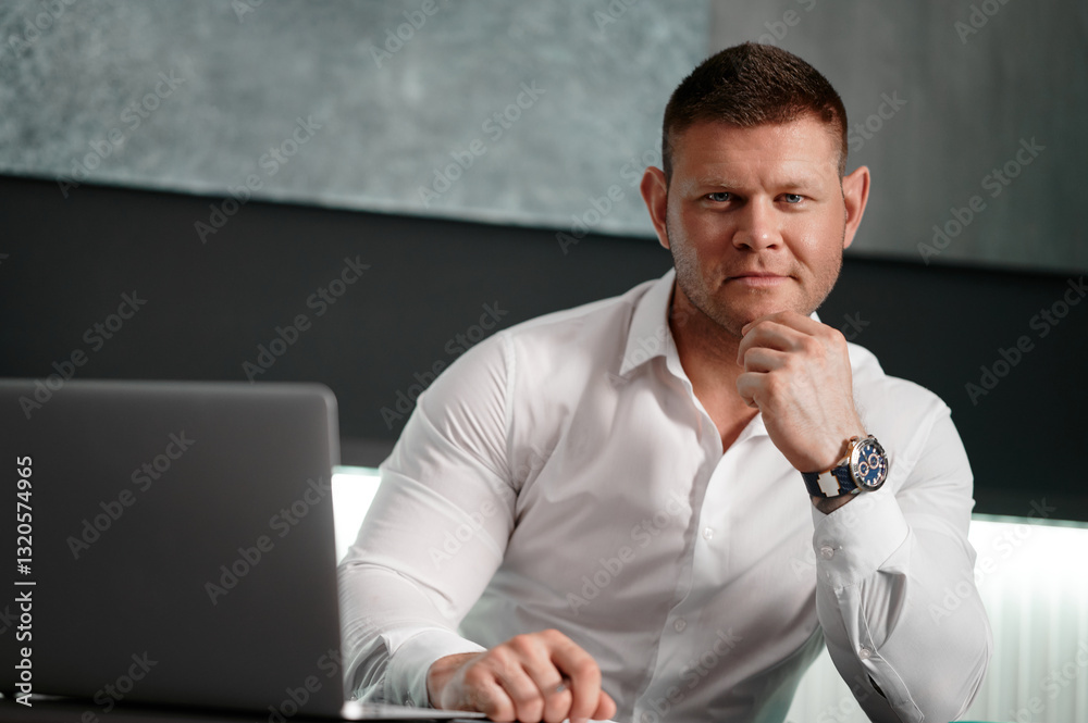 Smiling businessman with laptop. Man in a white shirt and a watch on his arm at a desk in an office is busy writing a business plan. Close-up of a businessman in a white shirt and a notebook. Smiling businessman with laptop. Man in a white shirt and a watch on his arm at a desk in an office is busy writing a business plan. Close-up of a businessman in a white shirt and a notebook.