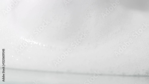 White dense soap foam close-up slow motion, cosmetic texture.
