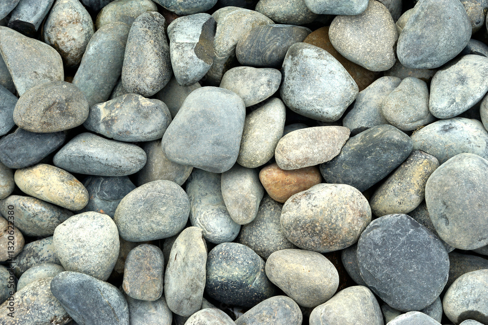 Smooth pebbles background or Gray pebbles on a pebble beach, top view. Smooth pebbles background or Gray pebbles on a pebble beach, top view.