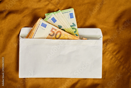 Obraz na płótnie Euro banknotes inside white envelope, top view. Close up of cash money on brown background. Concept of corruption, bribery, and hidden cash payments w salonie
