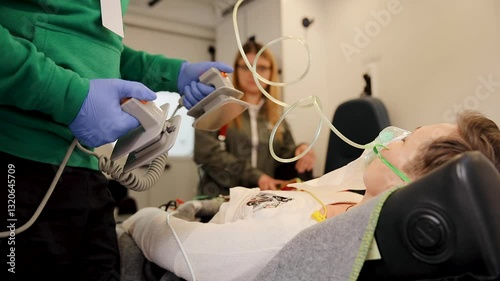 Emergency medical situation showing a professional using a defibrillator on a patient during lifesaving practice