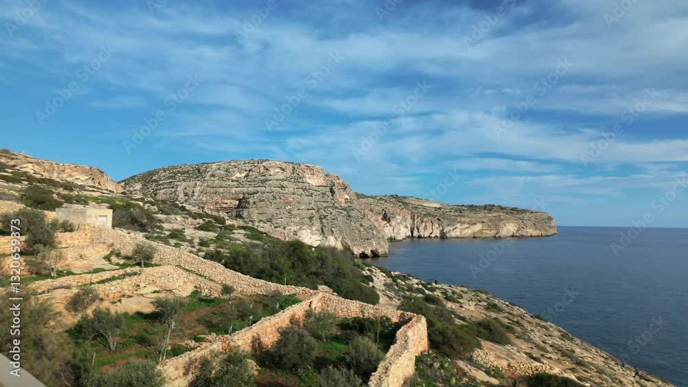 Steep limestone cliffs rise above the Mediterranean Sea along the Maltese coastline. Terraced stone walls and lush vegetation blend into the rugged landscape, showcasing Malta’s natural beauty. Steep limestone cliffs rise above the Mediterranean Sea along the Maltese coastline. Terraced stone walls and lush vegetation blend into the rugged landscape, showcasing Malta’s natural beauty.