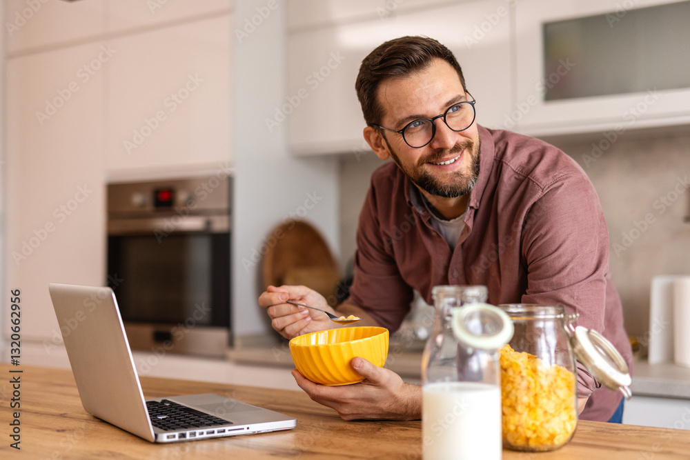 A bearded man in a modern kitchen enjoys a healthy breakfast while working on his laptop. He embraces work-from-home culture, balancing wellness and efficiency in a bright, inviting space. A bearded man in a modern kitchen enjoys a healthy breakfast while working on his laptop. He embraces work-from-home culture, balancing wellness and efficiency in a bright, inviting space.