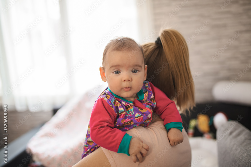 Caring mother holding newborn baby girl at home Caring mother holding newborn baby girl at home