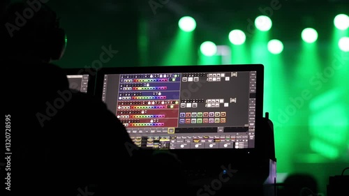 A detailed view of a lighting control panel used for managing stage lights during a live concert, with green stage lights in the background. Music concert. 4k video