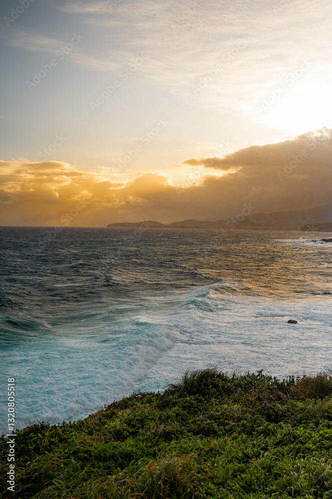 Obraz premium Golden Glow sunset over ocean cliffs