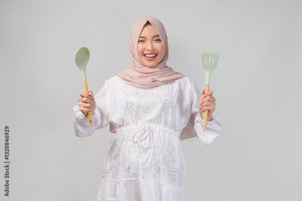 Portrait of Asian Muslim pregnant woman holding cooking tools or utensils while smiling. Portrait of Asian Muslim pregnant woman holding cooking tools or utensils while smiling.