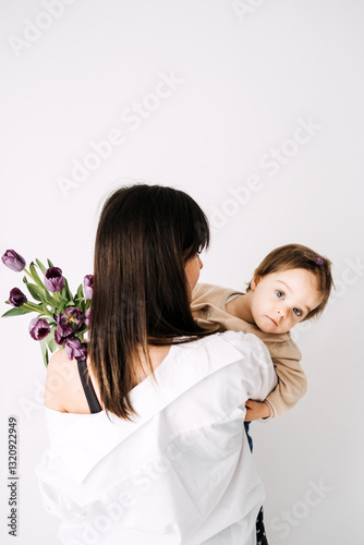 Mother and child admiring purple tulips. Real-life family moments, Mother's Day celebration, natural parenting, authentic connection, childhood curiosity.