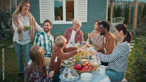 Wallpaper Mural People gathering together at table. Woman bringing dish and placing to other plates. Family thanking woman about tasty food. Female blushing. Covering face with both hands. Picknick. Torontodigital.ca