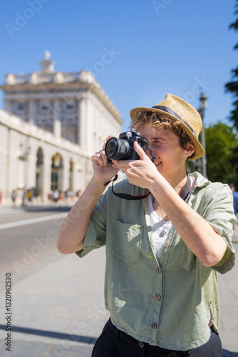 Tourist holding camera exploring madrid city center near royal palace