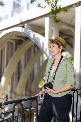 Woman photographer taking photos of a bridge in the city