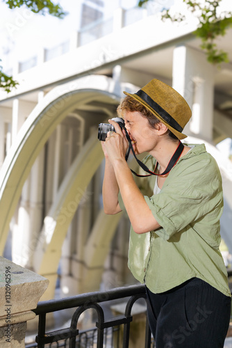 Woman photographer taking photos of a bridge in the city