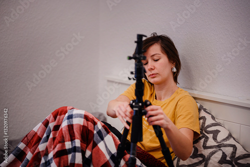 Wallpaper Mural Woman Assembling Tripod While Sitting in Bed Torontodigital.ca