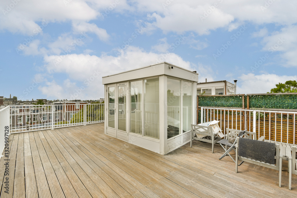 Fototapeta premium Spacious rooftop terrace featuring a contemporary glass pavilion, wooden deck, and seating area, offering a vibrant view of the surrounding cityscape.