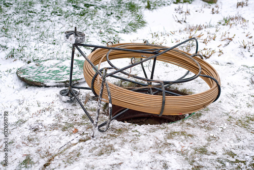 Obraz na płótnie Fiber optic cable spool for underground internet installation in winter conditions with snow covered ground and open manhole in telecommunications infrastructure project. Selective focus w salonie