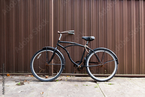 Retro bicycle against brown corrugated iron fence photo