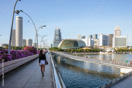 Asian woman walking on a bridge near the waterfront, Singapore City