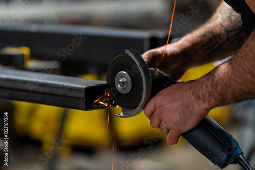 Dans un atelier de métallerie, gros plan sur un homme qui est en train de couper des barres de métal. L'art et la précision des métalliers dans leur environnement de travail. photo