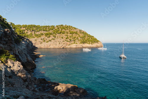 Elegant yachts moored anchor in picturesque harbor Port de Soller.Calm sea surface, sunny day. Mallorca, Spain, Balearic Islands. Travel, recreation at sea, yachting, photo