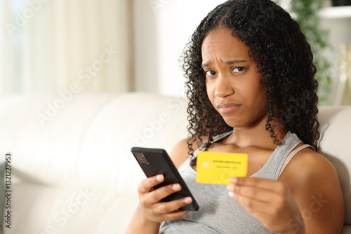 Disappointed black woman buying online looking at you