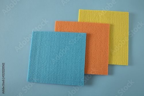 Blue, orange and yellow cloth on a blue shelf in a store waiting for a customer