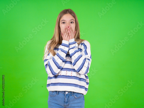 beautiful teen girl wearing striped sweater keeps hands on mouth, looks with eyes full of disbelief, being puzzled with amount of work