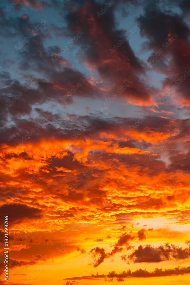 Fototapeta premium Sunset background vertical photo. Dramatic orange clouds